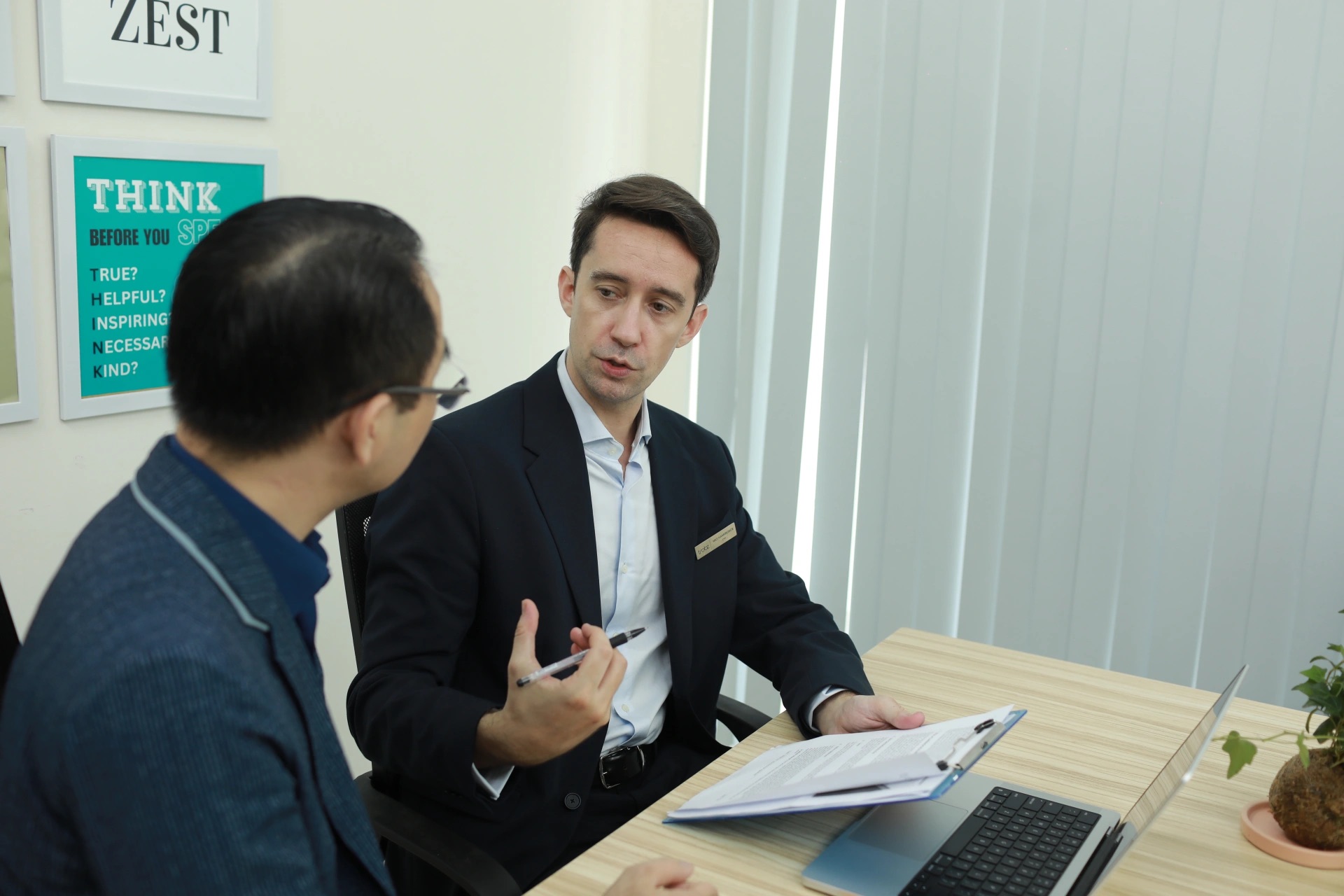 Two people discussing a project document at a desk